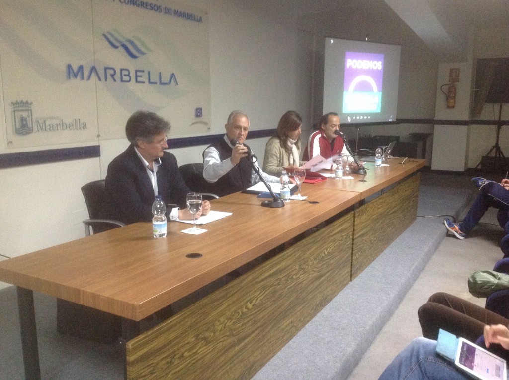 El exedil y dirigente local de IU Enrique Monterroso, micro en mano, durante el acto de Podemos celebrado este martes en Marbella. El primero por la izqda es el exedil del PSOE Juan Luis Mena. La tercera es la arquitecto Carola Herrero y al fondo el secretario local de Podemos, 'Lolo' González
