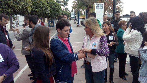 La 'número 1' al Senado del PP por Málaga, Ángeles Muñoz, coloca una pulsera con la bandera de España este domingo a un joven en Marbella. Foto/ Twitter PP Marbella-San Pedro