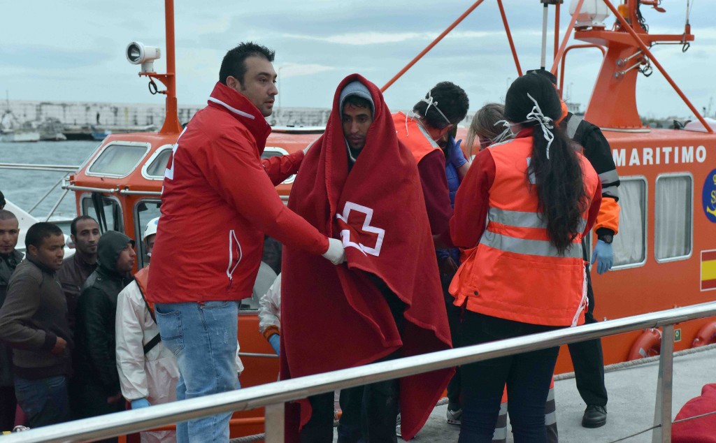 Personal de Cruz Roja atiende a los tripulantes de una patera a su llegada al puerto de La Bajadilla en imagen de archivo. Foto/ marbellaconfidencial.es