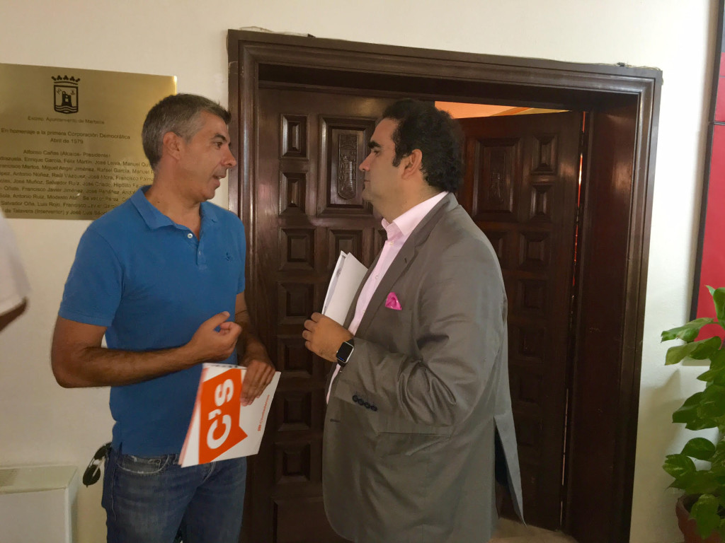 El coordinador de Ciudadanos en Marbella (carpeta de C's en mano), Miguel Ángel Hijano, conversa con el secretario general del PP y concejal, Manuel Cardeña, en imagen reciente antes de un pleno. Foto/ marbellaconfidencial.es