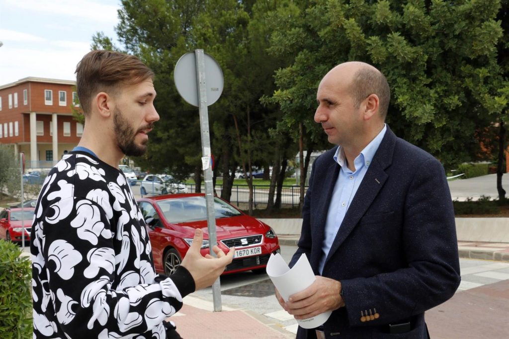 El número 5 por Málaga al Parlamento, Francisco Conejo, charla con un joven este domingo en Málaga. FOTO/ PSOE