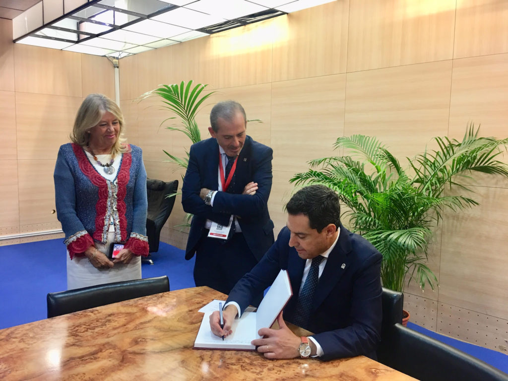 El presidente de la Junta, Juanma Moreno, firma en el libro de honor del ICA este viernes, en presencia de la alcaldesa de Marbella, Ángeles Muñoz y el decano del ICA, Francisco Javier Lara. FOTO/ CABANILLAS