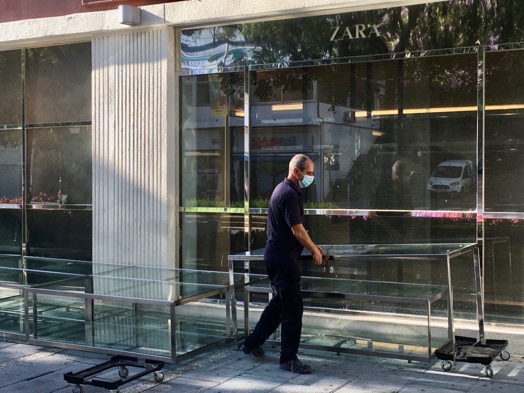 Un operario de Zara traslada estanterías y mobiliario interno a las puertas del establecimiento en Ricardo Soriano. FOTO/ CABANILLAS
